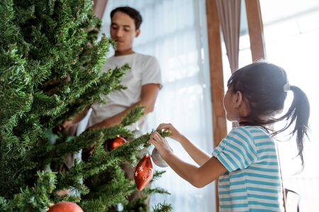 asian father and daughter installing christmas treeの写真素材