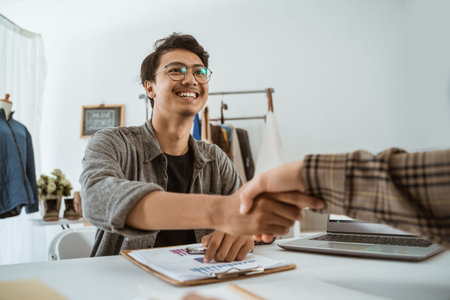male ecommerce shaking hand together in his office