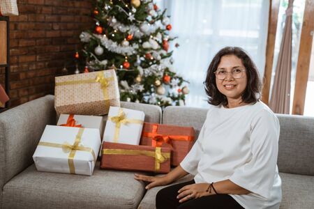 woman sitting on couch with gift boxの写真素材
