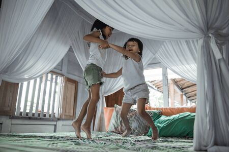 Two little girls jumping on bedの写真素材