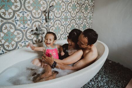 happy family with little daughter in bathtubの写真素材