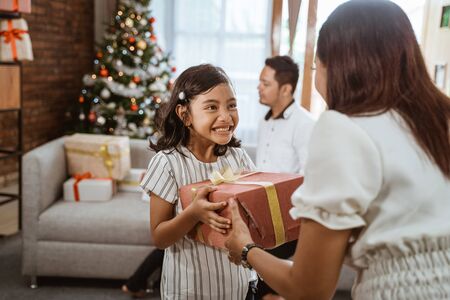 daughter giving her mom a present on christmas dayの写真素材