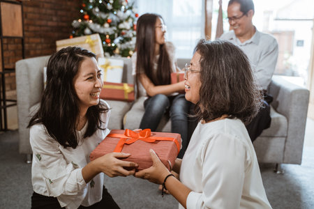 asian girl giving her mom present for christmas