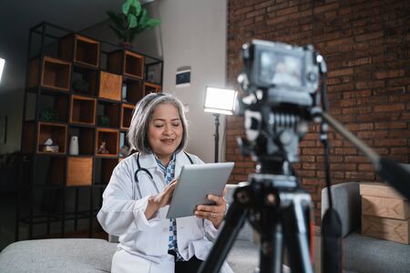 female doctor recording video for his blogの写真素材