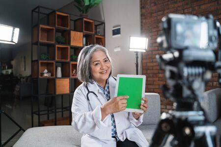 female doctor recording video for his blogの写真素材