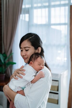 Mother carrying adorable little daughterの写真素材