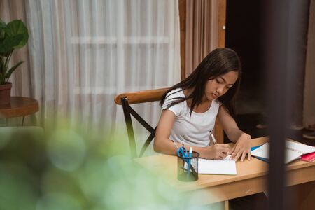asian teenager doing homework at homeの写真素材