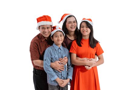 family smiling wearing christmas hat isolatedの写真素材