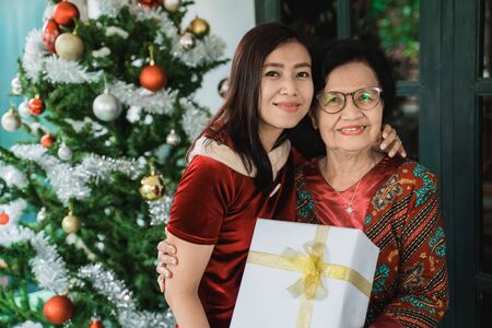 Daughter giving surprise gift to senior motherの写真素材