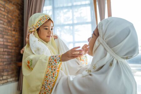 Muslim young child kiss her mom after prayingの写真素材