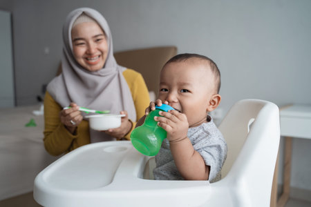 baby with bottle of water sitting on chair