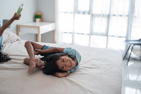 Flexible young girl on the bedの写真素材