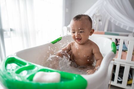boy toddler enjoy play with water while taking a bathの写真素材