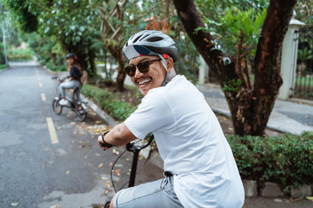 Asian youths look back and smiling when riding bicycles on the road