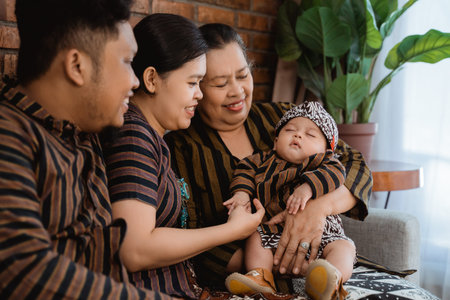 asian happy family sitting wearing javanese batik heritage