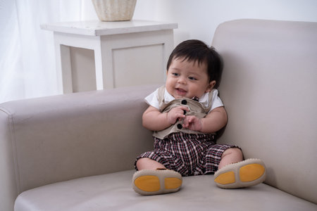 smile little boy sitting alone on sofa