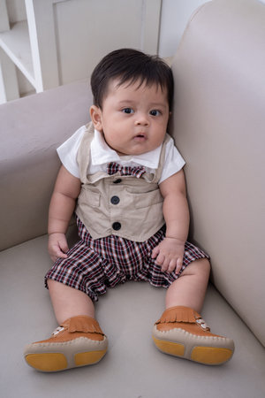 cute little boy sitting alone on couch