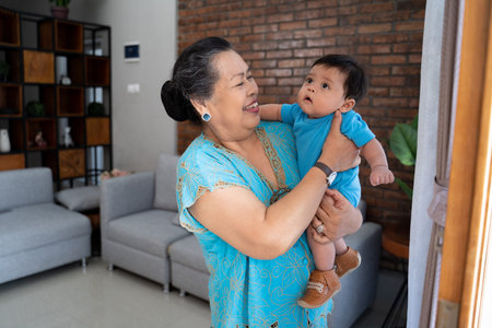 Grandma stand with carrying little grandson