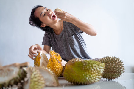 portrait of happy woman enjoy eating durian fruitの写真素材