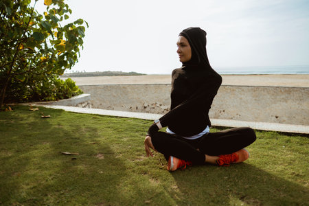 Healthy young muslim woman warming up outdoors