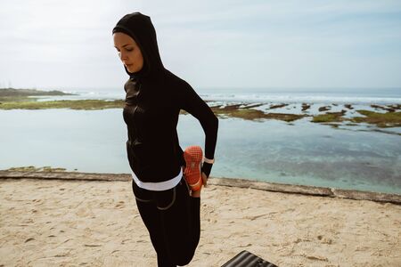 Healthy young muslim woman warming up outdoorsの写真素材