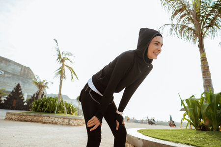 attractive runner taking break after jogging outdoors