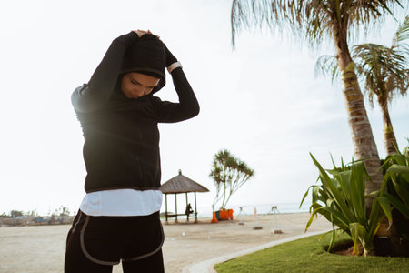 Healthy young muslim woman warming up outdoors