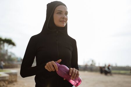 muslim woman drinking water bottleの写真素材