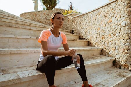 Attractive runner taking break after jogging outdoorsの写真素材