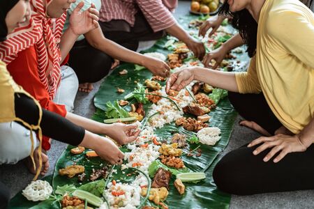 woman hand eating their food together laying on banana leafの写真素材
