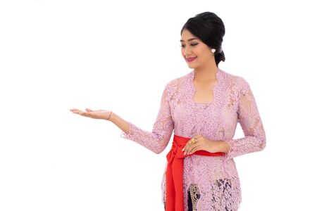 Young Balinese woman with presenting a productの写真素材