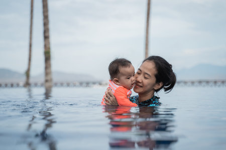 mother holds her baby while learning to swim