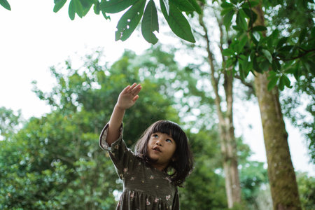 little girl imagines playing an airplane with her hands