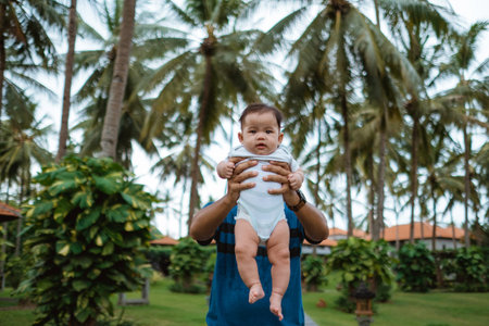 father carrying his baby outdoor