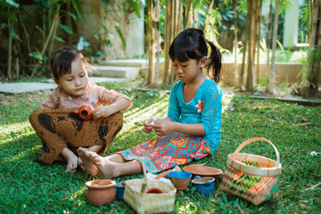 happiness two pretty girl wearing traditional javanese kebaya playing on the outside