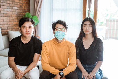 Male sick sitting between his friendの写真素材