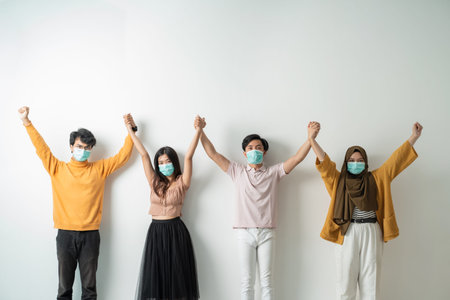 People with face masks hold hand