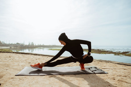 Woman with muslim sport wear stretching. sporty female using head scarf exercising