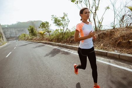 Sport woman running on side road.