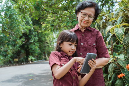 asian little girl enjoy watching a video using cell phone