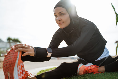 Healthy young muslim woman warming up outdoors