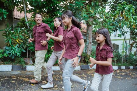 Asian family running outdoors smiling and having funの写真素材