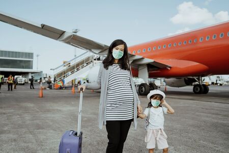 Pregnant women and her daughter with masksの写真素材