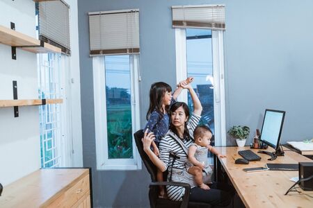 businesswoman working while taking care childrenの写真素材