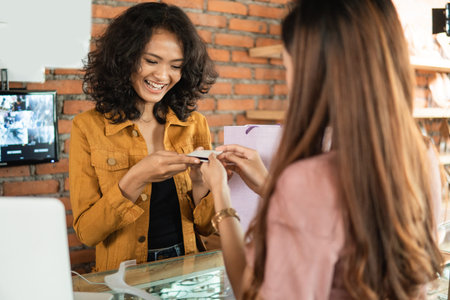 beautiful female cashier take credit card for payment