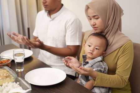 family pray before having dinner togetherの写真素材