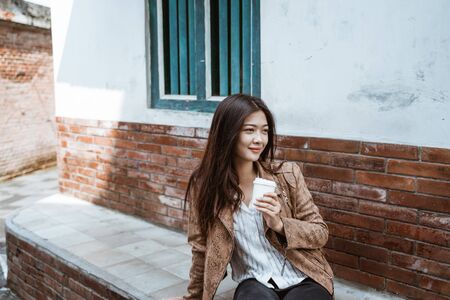 woman sit while enjoy a cup of coffee in the morning before workの写真素材