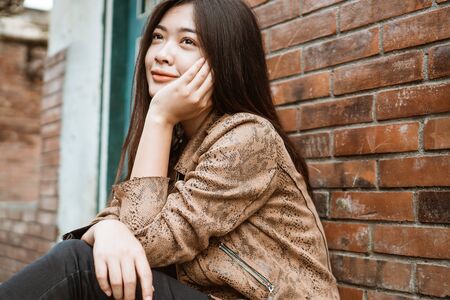 attractive asian woman portrait smiling wearing brown jacketの写真素材