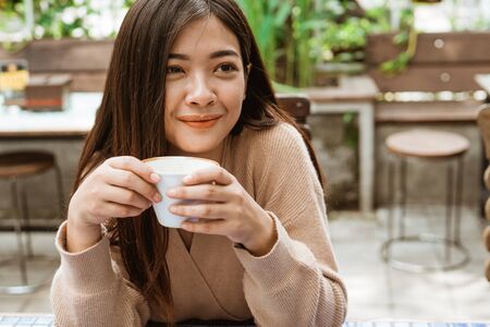 attractive woman enjoy drinking coffee by herself in cafeの写真素材