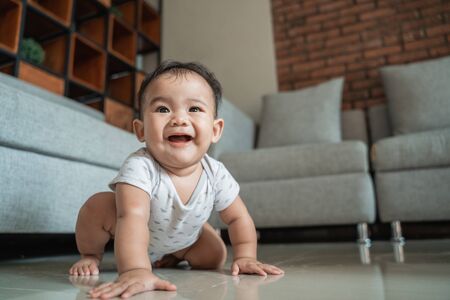 baby learn to crawl on the floor at homeの写真素材